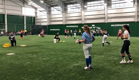 Competitive Edge girls playing softball on field indoor